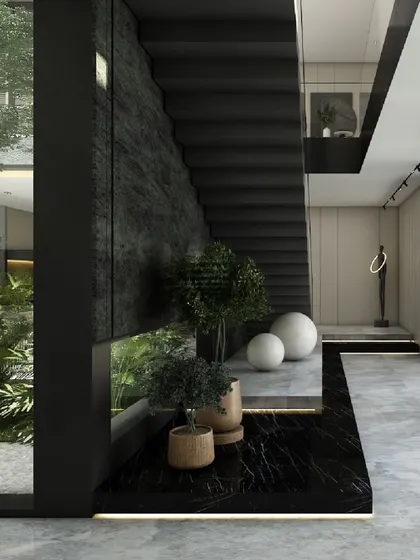 In the 'House of Courtyards', this corridor is defined by a monolithic black stone wall and a floating staircase. The space is designed to connect visually with adjacent courtyards, blending raw materiality with natural elements.