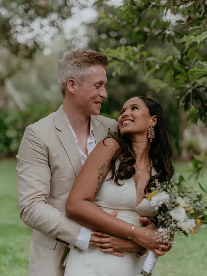 A sweet, candid moment between a couple in a garden setting during their destination wedding at Punnamada Resort.
