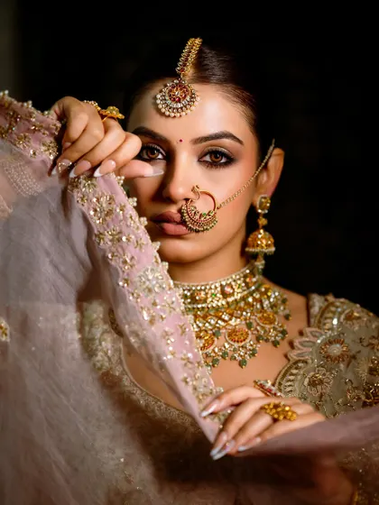 A close-up that showcases the intense and dreamy eye makeup. The veil adds a touch of mystery and tradition to this otherwise modern and glamorous bridal look.