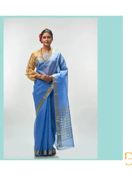 A full-length portrait in the cornflower blue saree, a picture of grace and timeless style.