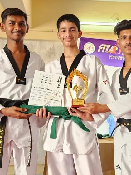 Two of our black belt coaches award a student his new green belt, certificate, and trophy. We recognize and reward the hard work of our students.