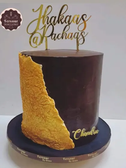 This tall, single-tier chocolate truffle cake makes a bold statement with its dark ganache and a striking gold textured fault line. The "Jhakaas @ Pachaas" topper adds a fun, personalized touch for a 50th birthday.