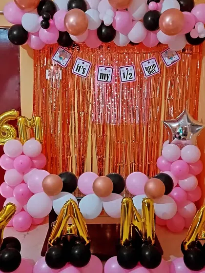 A cute half-birthday (6 months) celebration with a rose gold shimmer curtain and a pink, black, and rose gold balloon frame.