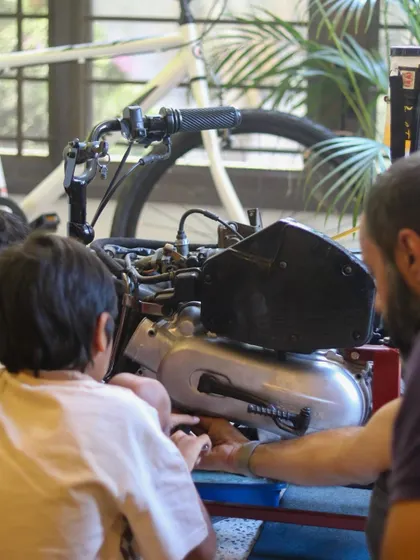 I guide a student as they inspect the internal combustion engine. These moments of direct mentorship are key to building both skills and confidence.