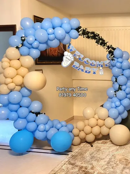 A "Welcome Baby Boy" setup with a blue and cream circular balloon arch.