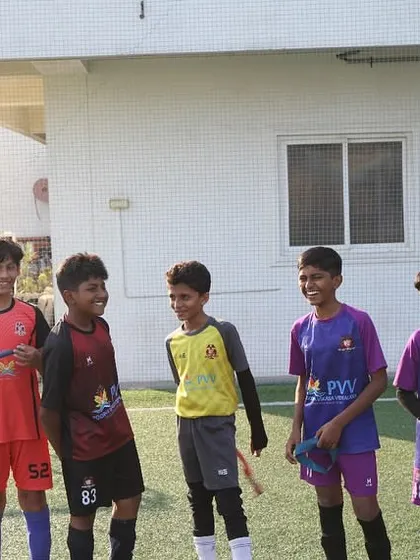 The joy of the game shines through. Young players share a laugh during a break in training, showcasing the friendships and positive atmosphere we foster at the academy.