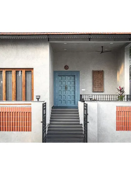 With a modest elevation, we wanted the main door to be an eye-catching feature. We conceptualized a traditional carved teak door but chose to polish it in a gorgeous steel blue that stands out, telling a story of being traditional yet unconventional.