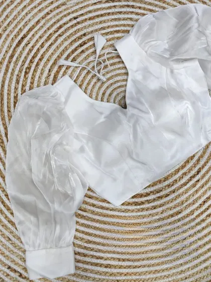 A classic white organza blouse with balloon sleeves, a versatile and trendy piece.