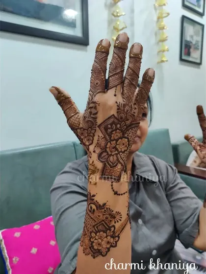 A unique designer mehendi for one hand. The floral pattern is contained within a geometric shape, creating a very modern and artistic look.