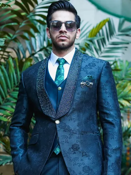 A full shot of the dark teal floral tuxedo, a perfect ensemble for a wedding guest or for a reception party. The custom fit ensures a sharp and flattering silhouette.