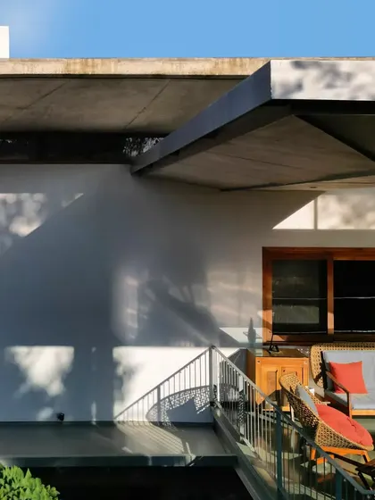 The exterior of the 'House of Canopies', where cascading, cantilevered concrete roofs provide shelter and create a distinctive, modern silhouette.