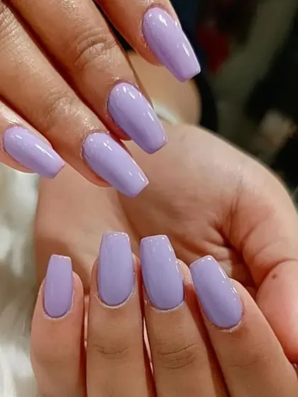A lovely solid lavender color on medium-length coffin-shaped nails, a perfect pastel shade for any season.