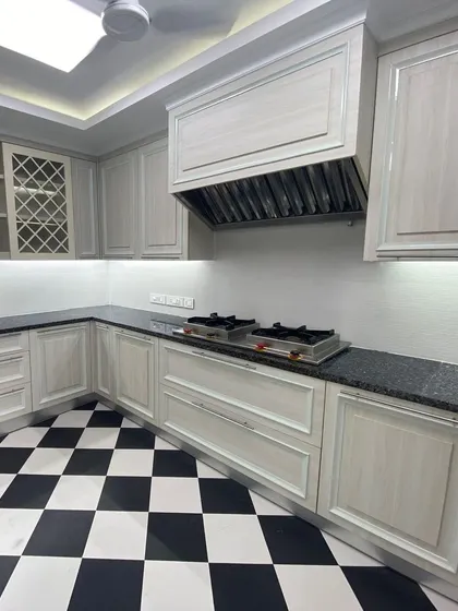 Another view of the office kitchen, showcasing the custom cabinetry with integrated wine racks and ample storage. The under-cabinet lighting and clean lines contribute to a space that is both highly functional and visually appealing.