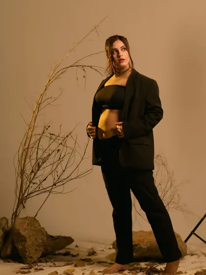 A bold and confident pose. This studio shot, with its earthy tones and minimalist props, showcases a modern and empowered vision of the mother-to-be.
