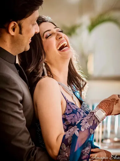 A candid shot of the couple laughing together. This image perfectly captures the joy and comfort they find in each other's company.