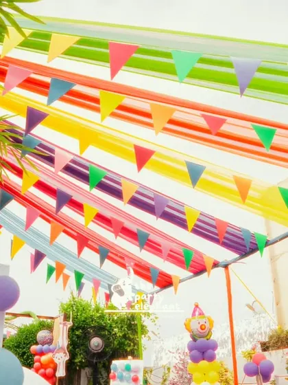 Creating a festive atmosphere is all about the details. I hung streams of colorful fabric and bunting flags overhead to give the entire outdoor carnival space a vibrant, celebratory canopy.