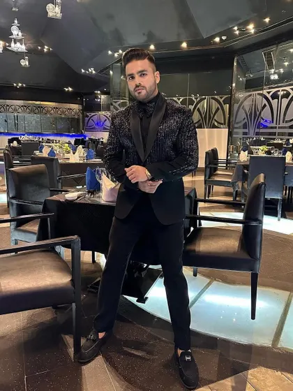 Another view of the client in the all-black sequin tuxedo, highlighting its shimmer and modern design.