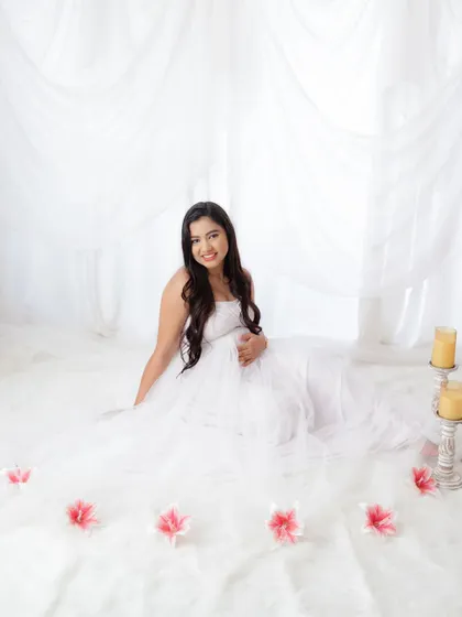 An angelic portrait in all white. The soft, fluffy rug and sheer white curtains create a dreamy and serene setting for this beautiful mama-to-be.