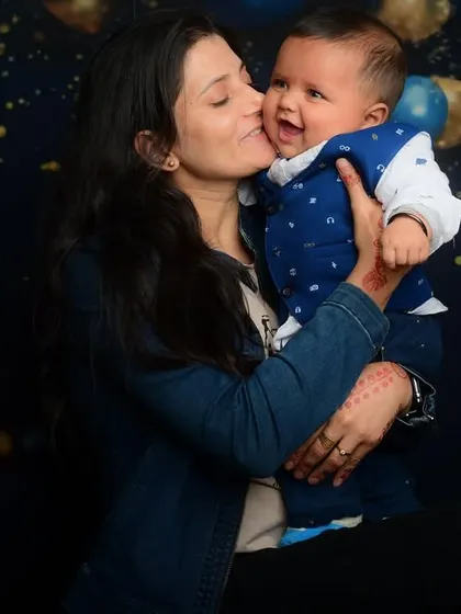 A mother's love captured in a sweet kiss. This was taken against a festive balloon backdrop in my studio, perfect for celebrating a milestone.