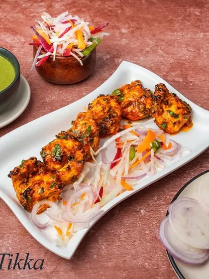 Achari Tikka brings the tangy and spicy flavors of Indian pickles to a kebab. The chicken is marinated in a yogurt base infused with pickling spices like mustard, fennel, and fenugreek for a zesty kick.