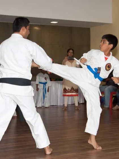 A demonstration of a basic sparring drill, where a student practices a front kick against an instructor. This is fundamental to building timing and distance for kumite.