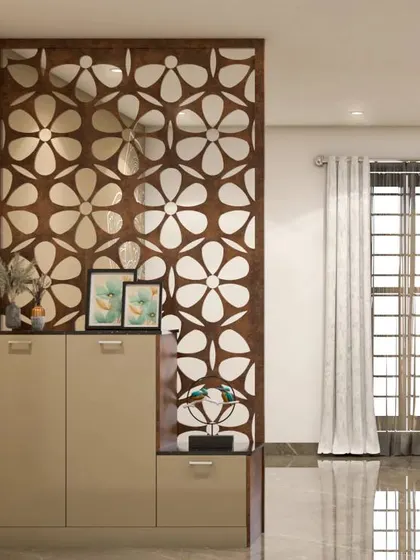 This foyer features a beautiful floral-patterned jali partition behind a sleek, modern shoe cabinet. The design adds a decorative touch while providing privacy.