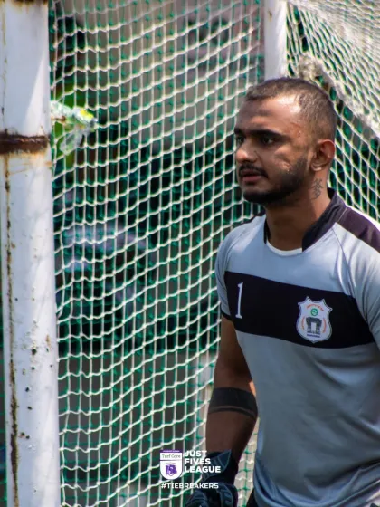 A goalkeeper stands focused and determined, watching the play unfold. Concentration is key to making those crucial saves.