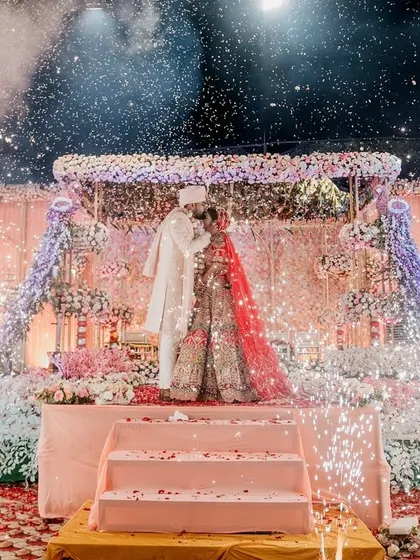 The couple shares a kiss on stage after their varmala, surrounded by a spectacular display of cold pyros, creating a perfect finale moment.