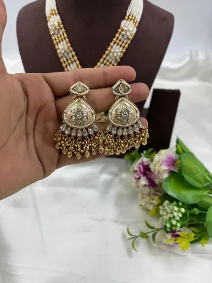Our "Indira" premium antique gold necklace set. This long necklace features a large, intricately designed pendant with Meenakari work and comes with matching statement earrings.