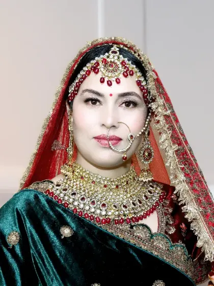 A close-up shot focusing on the bride's beautiful face, her intricate jewelry, and the rich colors of her traditional attire.