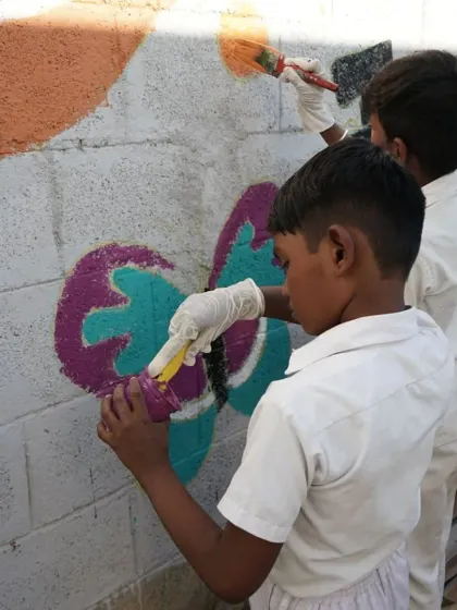 A young artist carefully painting a butterfly. During these community wall art projects, I see so much focus and passion in the kids. It reminds me that creativity is a natural instinct, and all they need is the space and freedom to express it.