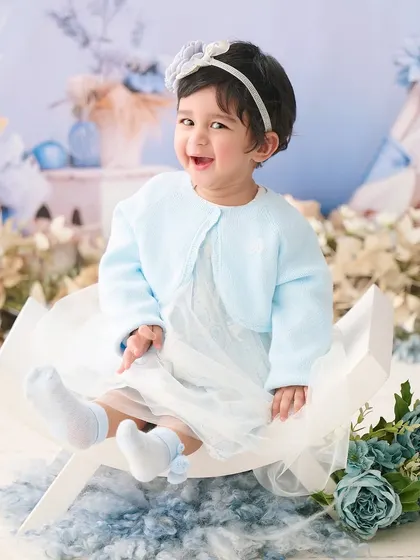 A vision in blue. This coordinated setup with a soft blue outfit and matching floral background is perfect for a sweet and gentle portrait.