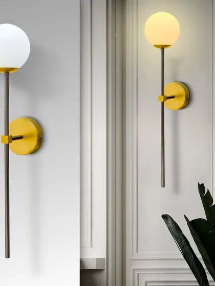 A modern globe wall sconce with a yellow base, adding a pop of color and a soft, diffused light.