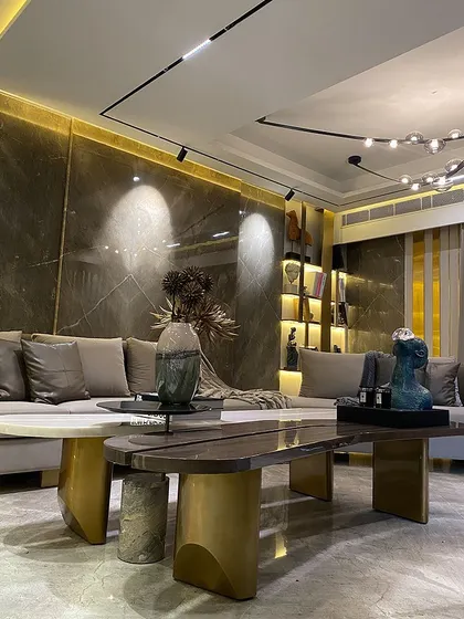 This shot showcases the interplay of lighting and materials. Spotlights and ambient backlighting highlight the texture of the marble wall, while a modern, branching chandelier provides general illumination for the lounge.