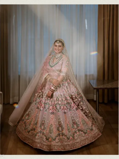 A happy, radiant portrait of the bride in her stunning floral lehenga.