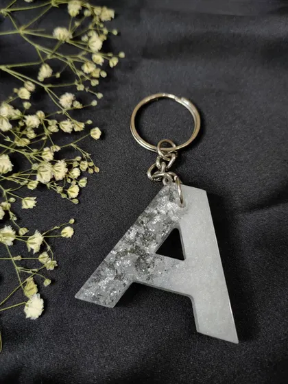 A classic and elegant initial keychain in pearl white and silver flakes. This combination is timeless and matches with everything.