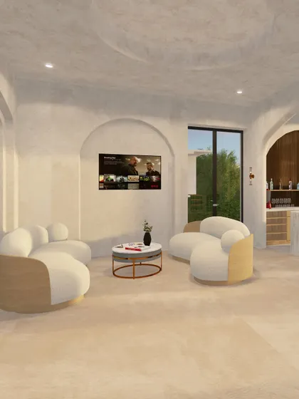A view of the lounge area, where curved, modern sofas are set within an arched niche. The entire space is finished in harmonious calcitriol lime wash and travertine textures, creating a soft, earthy, and inviting retreat.