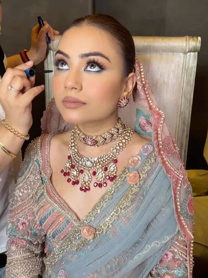A stunning shot of the bride during her makeup session, with her hair prepped for a sleek updo.
