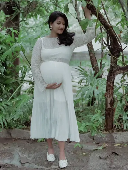 Capturing the serene glow of motherhood. This solo maternity portrait uses soft, natural light in a garden setting to create a timeless and elegant feel.