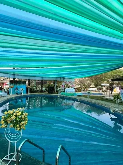 Another view of the poolside setup, showing the fabric canopy and the seating arrangement around the pool, demonstrating how we manage decor for large spaces.