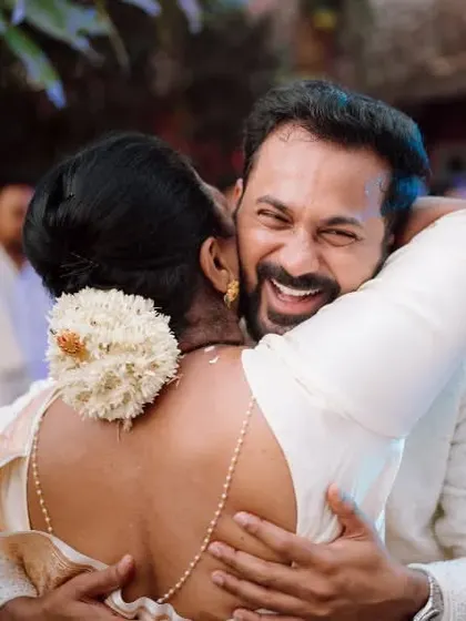The groom shares a happy hug with his mother, a touching moment from the wedding day.