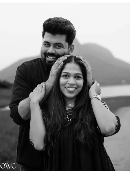 A playful and happy black and white portrait of a couple, with a beautiful mountain landscape in the background.