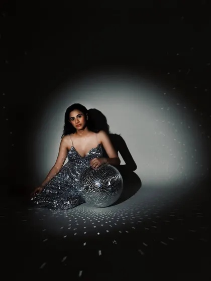 A portrait from a birthday celebration shoot, with the subject seated with a disco ball. It’s a fun, glamorous way to mark a milestone.