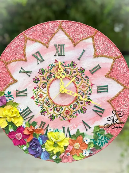 This 14-inch Russian sculptured wall clock features a pink base with intricate center detailing and Roman numerals. The bottom is adorned with a rainbow of multi-colored flowers, making it a truly joyful and detailed piece.