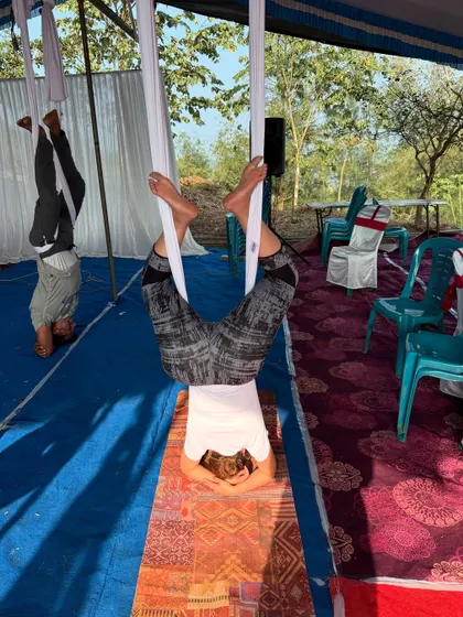 Two participants practicing inversions side-by-side. The shared experience of trying something new and challenging builds a strong sense of community.
