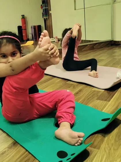 A young yogi explores her flexibility in this seated leg stretch. It's amazing to see children discover what their bodies are capable of.