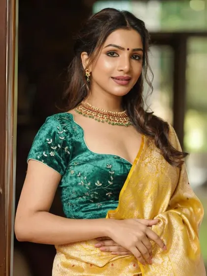 This model wears a green velvet blouse with delicate embroidery, paired with a simple gold choker that highlights the richness of the fabric.
