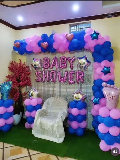 This angle shows the complete baby shower corner, with a decorated chair, balloon arch, and pillars, creating a perfect spot for the main ceremony and photos.