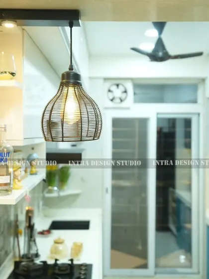 Details matter. Here, you can see the industrial-style pendant lights we chose for the breakfast counter, adding a touch of rustic charm to this modern blue kitchen. The open shelves provide easy access to everyday items.