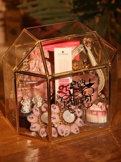 Another angle of the house-shaped glass box, filled with personalized gifts for a special Diwali celebration.